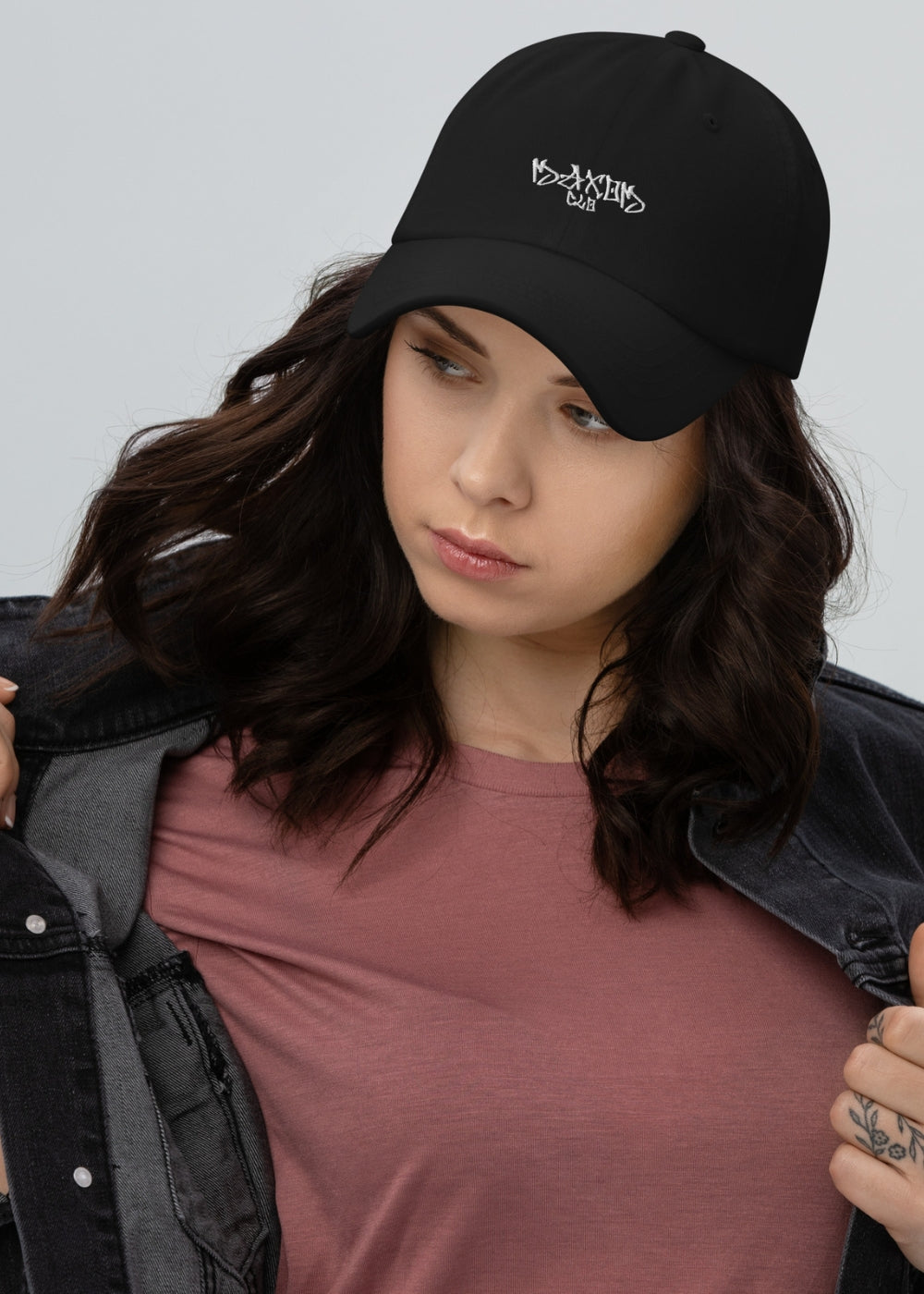 Female model wearing black minimalist baseball cap – sleek unisex design with adjustable strap and chino cotton twill texture.