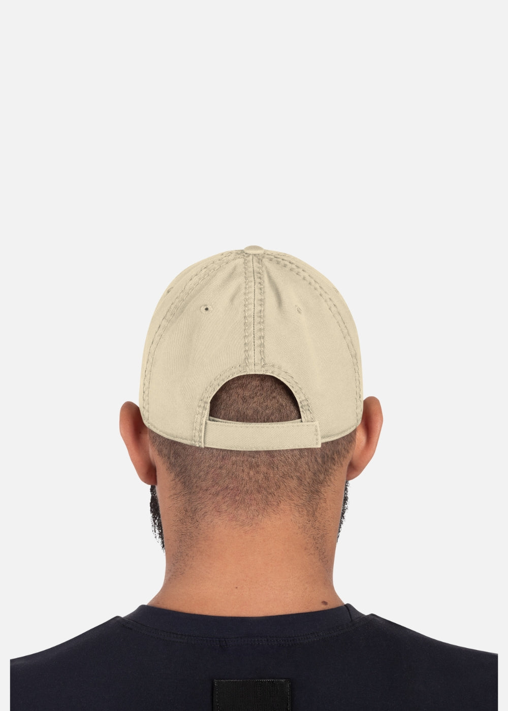 Back view of male model with khaki adjustable distressed cap – casual streetwear vibe with bold rugged details.