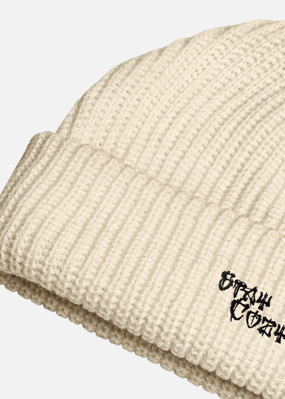 Detail of beige knit streetwear beanie – ribbed design and embroidered cross for cozy winter looks