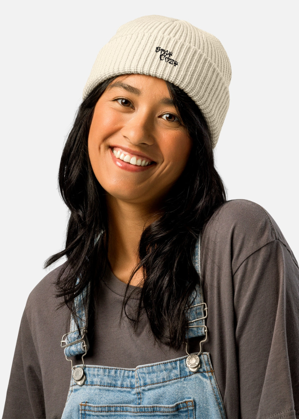 Female model in beige urban streetwear beanie – minimalist ribbed design with bold cross detail