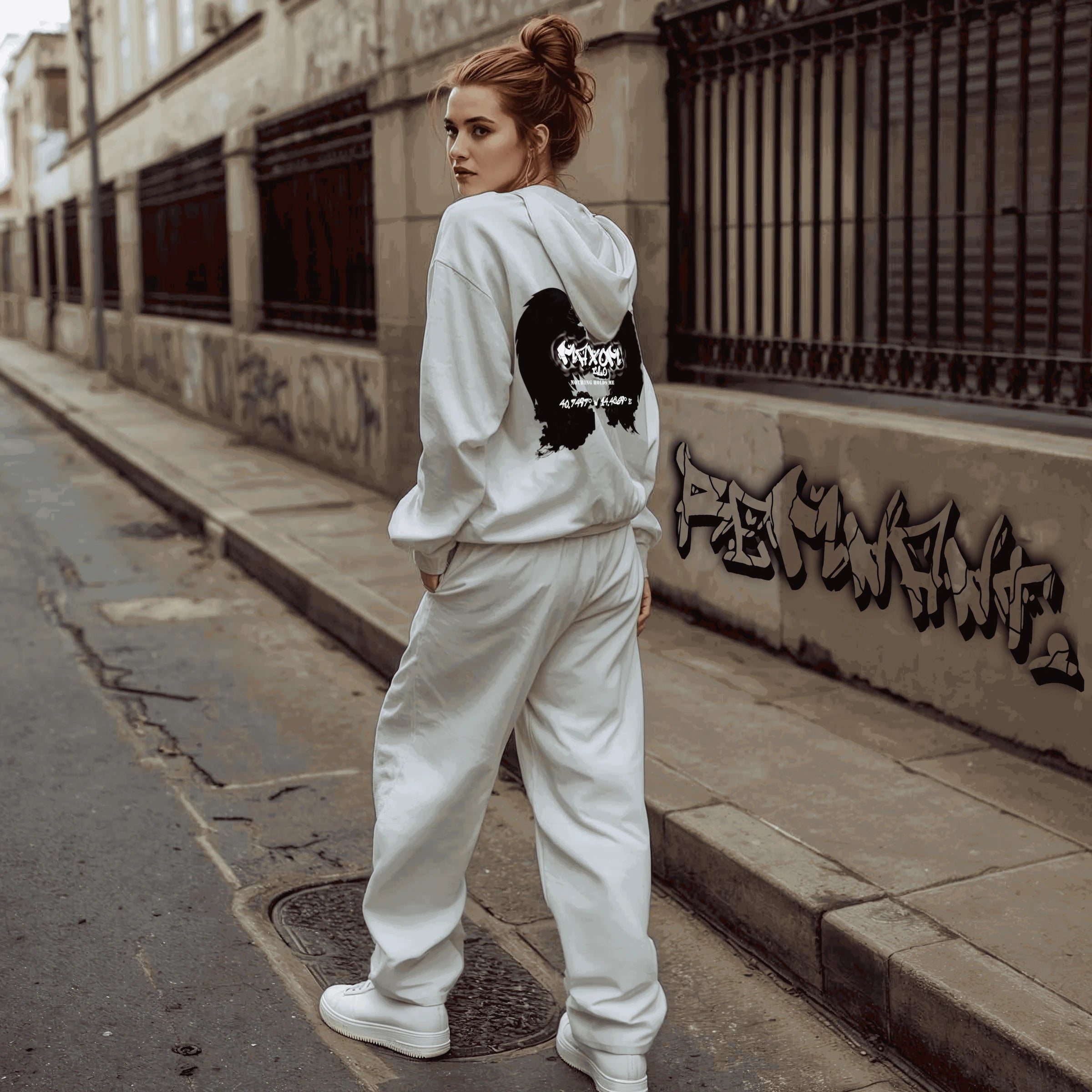 Woman wearing grey oversized graffiti hoodie and sweatpants set with angel wings and Nothing Holds Me quote – unisex heavyweight streetwear look for winter 2025.