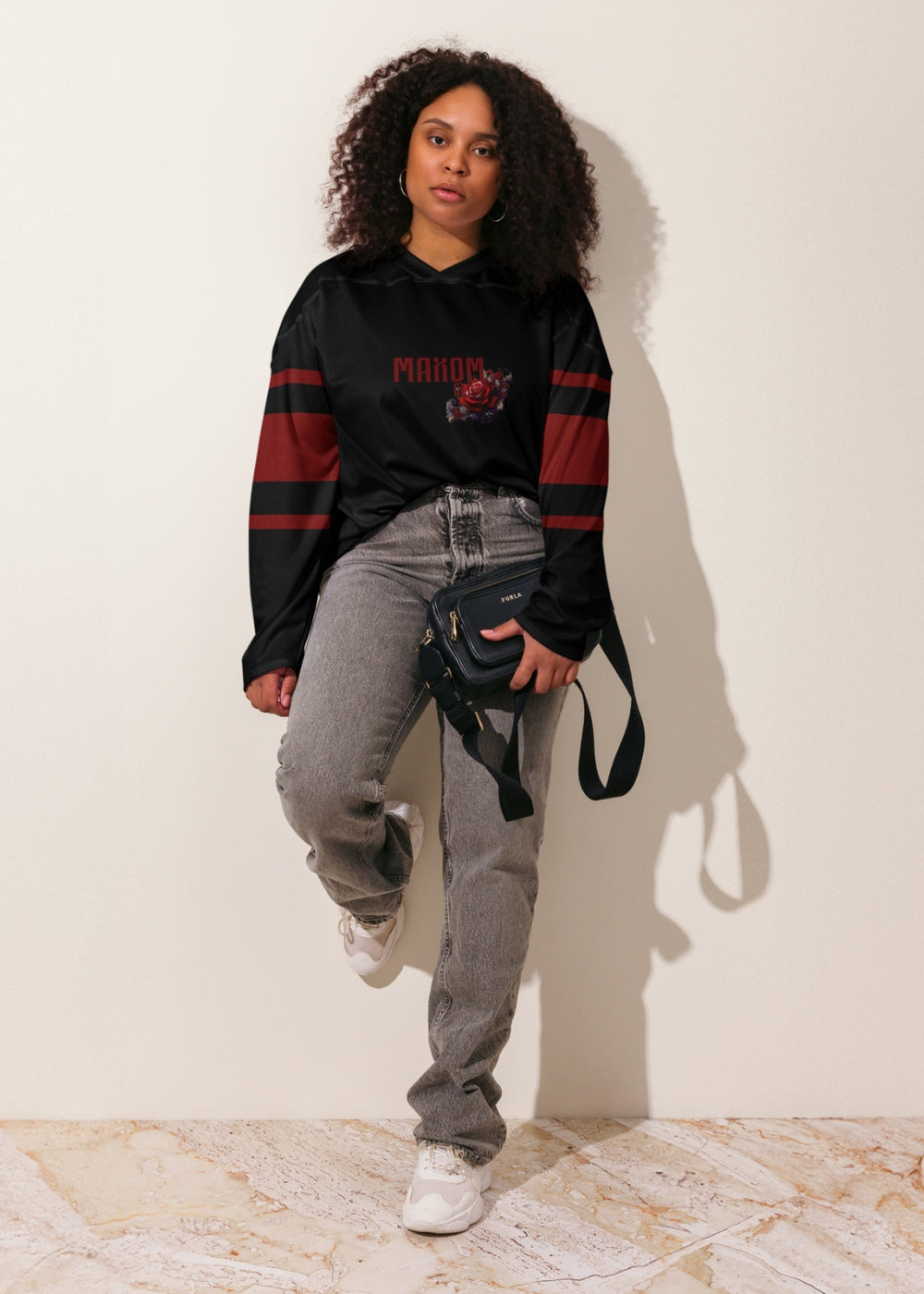 Female model in real-life urban setting wearing MAXOMclo recycled hockey sweater – floral streetwear with purpose