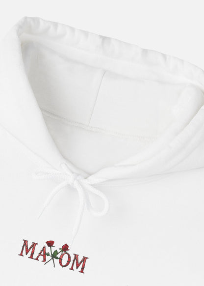 Detailed close-up of white hoodie showing rose print and inspirational back quote