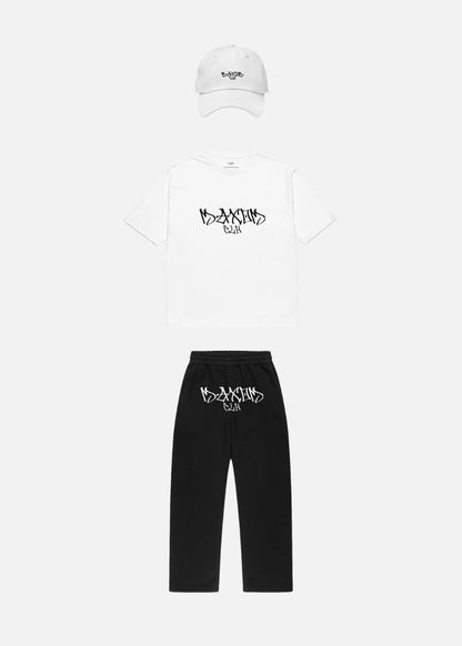 Skullflow Essentials Bundle front with white cap – relaxed tee and joggers paired with crisp cap for a clean urban aesthetic.

